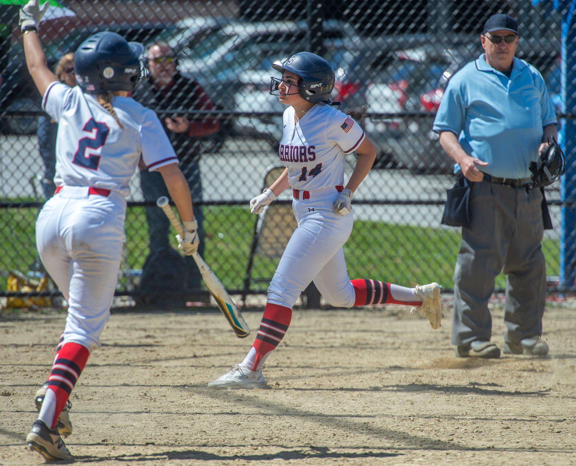 Lincoln-Sudbury Regional High School softball junior Sophie Jorjorian, center, scores the winning run in the seventh inning against Hopkinton on a passed ball, April 16, 2024. The final score was 8-7.