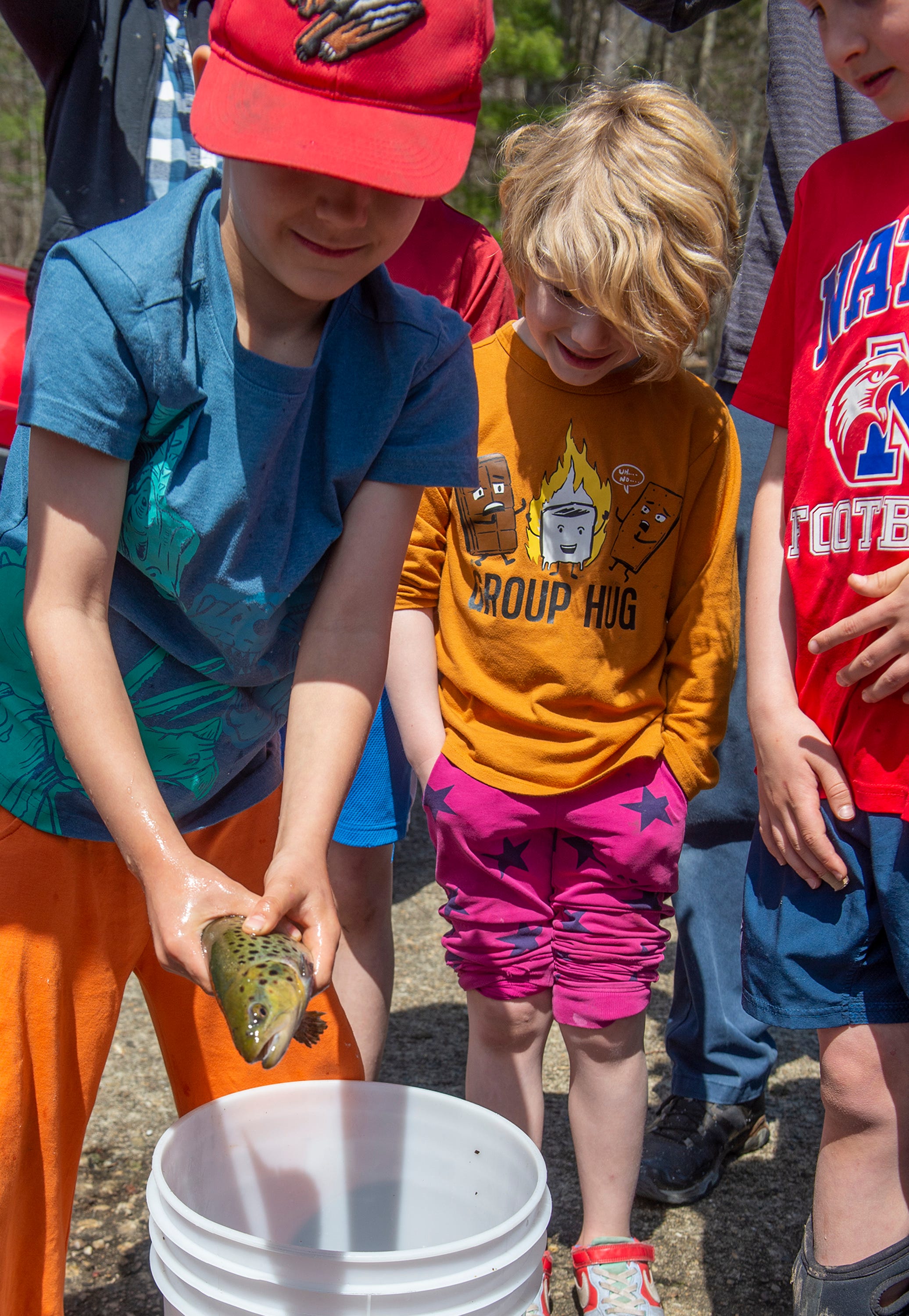 Llewellyn Schmidt, 6, of Upton, releases one of 400 brown trout from the Mass Wildlife Sunderland Hatchery into the Hopkinton Reservoir at Hopkinton State Park, April 17, 2024. Mass Wildlife is releasing 500,000 trout into Massachusetts waters this Spring.